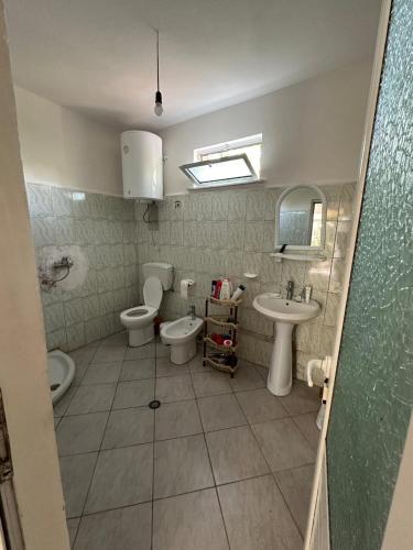 a bathroom with two toilets and a sink at Private house surrounded by greenery in Fier