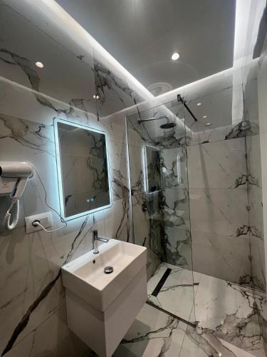 a white bathroom with a sink and a mirror at Villa Niku Berat in Berat
