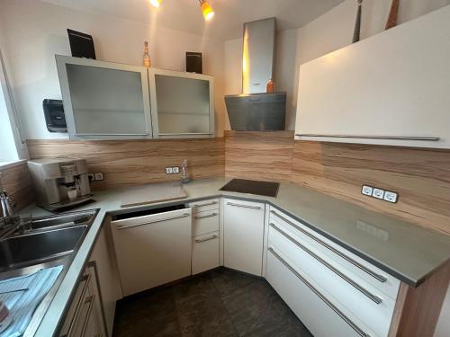 a kitchen with white cabinets and a counter top at Tabita 2, with 3 sleeping rooms in Untermeitingen