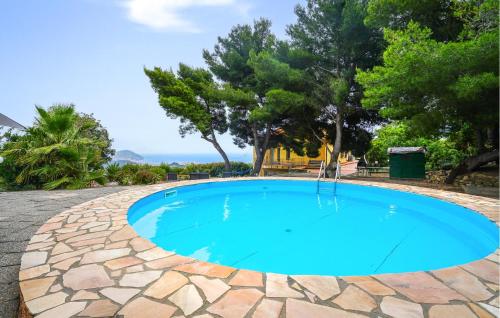 una piscina con acqua blu in un camminamento in pietra di 3 Bedroom Cozy Apartment In Imperia a Imperia