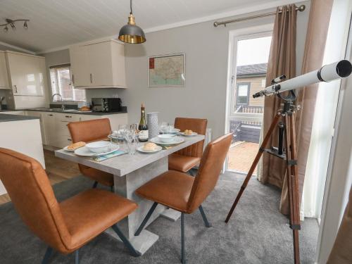a kitchen and dining room with a table and a camera at Hazelwood 2 Pinewood Retreat in Lyme Regis
