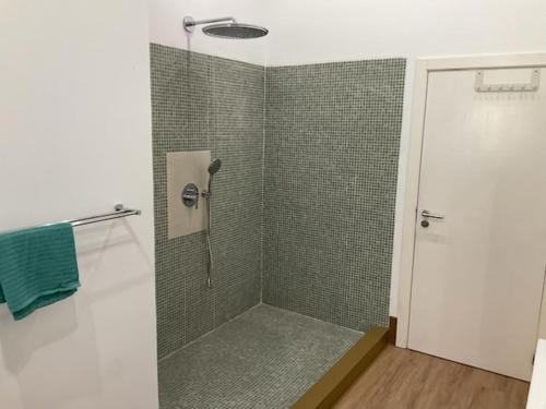 a bathroom with a shower with a glass door at Cantinho do Carmo in Fragoso