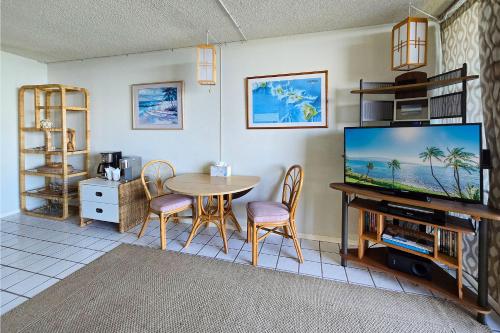 a living room with a table and a tv at New! Maalaea Banyans 204 - Expansive Ocean Views! in Wailuku