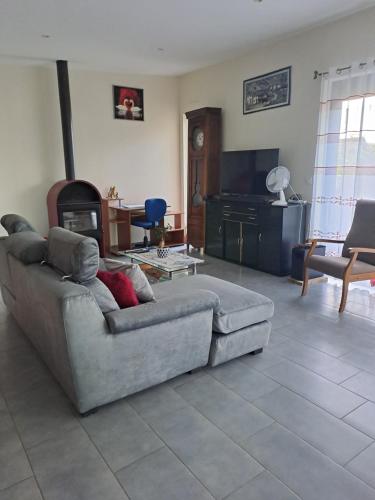un salon avec un canapé et une télévision dans l'établissement Maison en campagne, à Meillac
