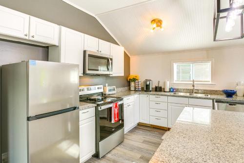 a kitchen with white cabinets and a stainless steel refrigerator at Bayfront Steuben Home with Screened Porch and Fire Pit in Steuben