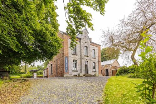 an old brick building with a driveway in front of it at Le repos Ardenne (Fays-Famenne) in Wellin
