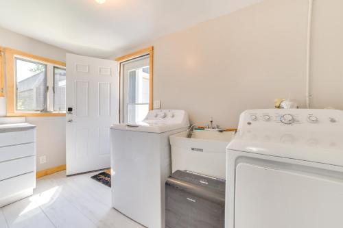 una lavanderia bianca con lavatrice e asciugatrice di Houghton Lake Cottage with Patio Walk to Waterfront a Houghton Lake