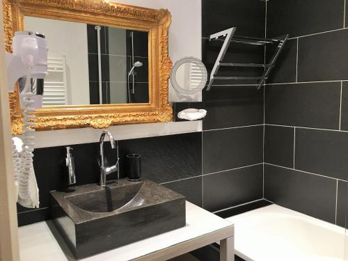 une salle de bain avec un lavabo et un miroir dans l'établissement Appartement La Borde, à Dijon