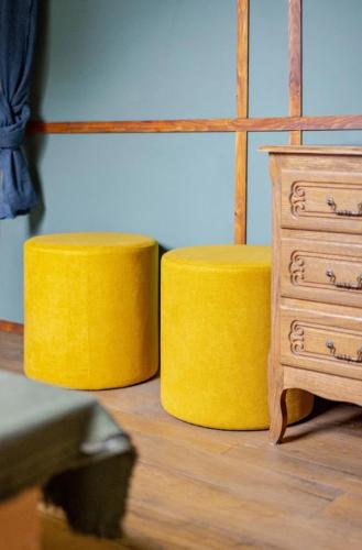 two yellow stools next to a dresser and a drawer at Le repos Ardenne (Fays-Famenne) in Wellin