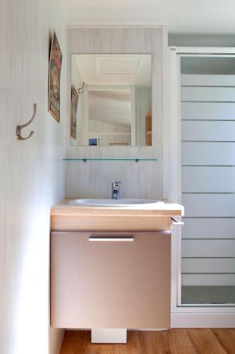 une salle de bain avec un lavabo et un miroir dans l'établissement Camping du Val de l'Eyre, à Salles