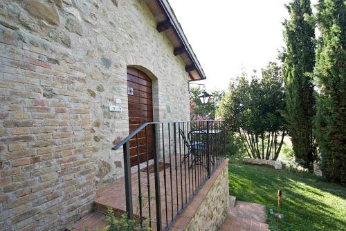a brick building with a wooden door and a gate at Casale del Monsignore in Spoleto