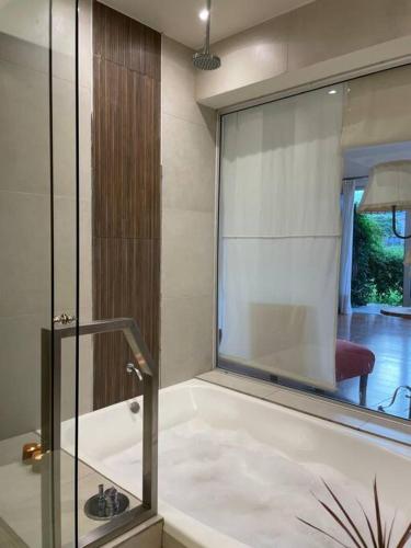 a bathroom with a bath tub with a glass window at Mein haus in Salta