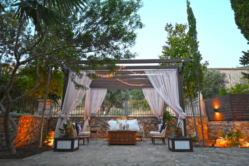 a pergola with a bed and a table and chairs at Petrino Villa Ianthe in Véssa