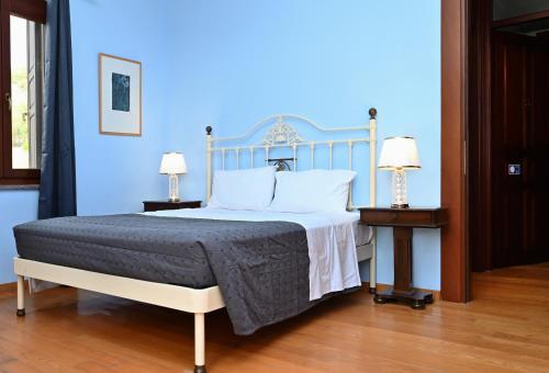 a bedroom with a bed with a blue wall at Petrino Villa Ianthe in Véssa