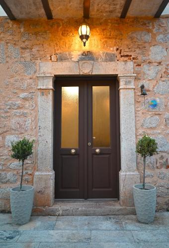 a black door with two potted plants in front of it at Petrino Villa Ianthe in Véssa