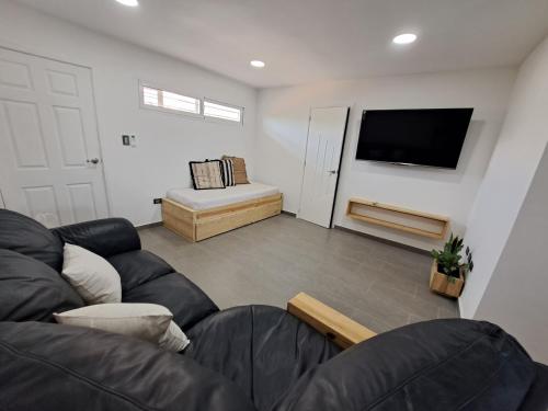 a living room with a couch and a flat screen tv at Yaque Suite in El Yaque