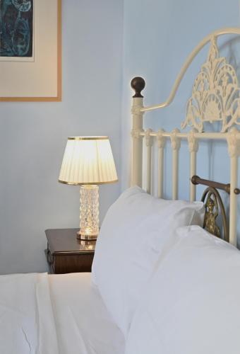a white bed with a lamp on a table at Petrino Villa Ianthe in Véssa