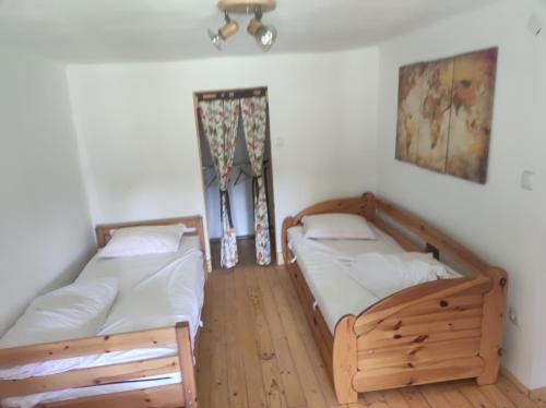 two twin beds in a room with a window at Bambusz ház in Rábapaty
