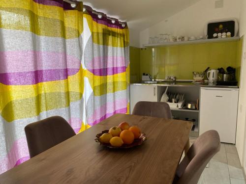 a kitchen with a table with a bowl of fruit on it at Apartments and Rooms Radivojević Niš in Niš