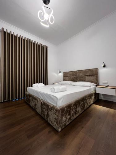 a bedroom with a large bed and a chandelier at Villa Niku Berat in Berat