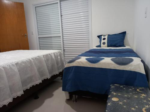 a bedroom with two beds and a window at sobrado 08 com duas suítes, conf in Guarujá