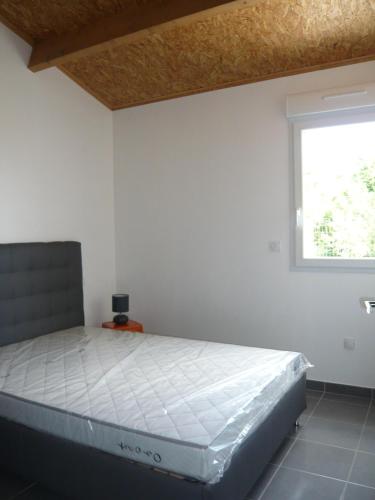 une chambre avec un lit dans une pièce avec une fenêtre dans l'établissement Le Fief de Belmont, à Médis