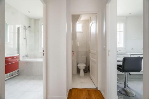 Elle comprend un bureau et une salle de bains blanche pourvue de toilettes. dans l'établissement Splendide 2 pièce à Boulogne, à Boulogne-Billancourt