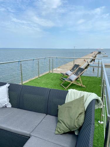 a couch sitting on the balcony of a cruise ship at Domek na wodzie Houseboat Frombork in Frombork