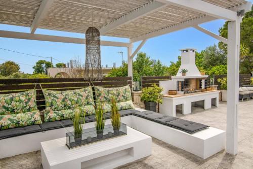 a patio with a black and white couch and a grill at Villa Zante Pnoe by Villa Plus in Pandokrátor