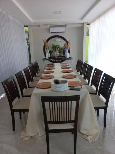 a long table with chairs and plates on it at Casa das Seringueiras in Alter do Chao