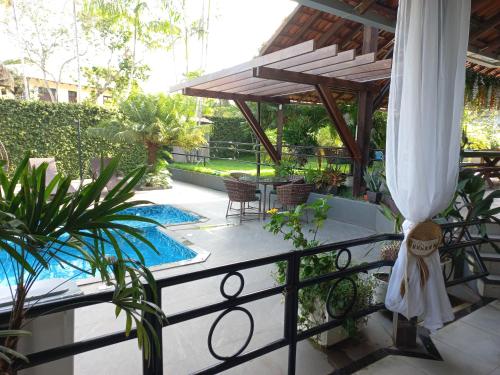 a balcony with a swimming pool and a umbrella at Casa das Seringueiras in Alter do Chao