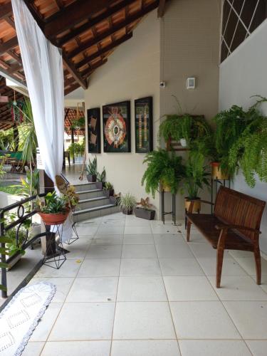 a patio with a bench and potted plants at Casa das Seringueiras in Alter do Chao