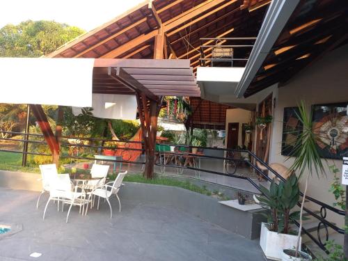 a patio with white chairs and a table and a building at Casa das Seringueiras in Alter do Chao