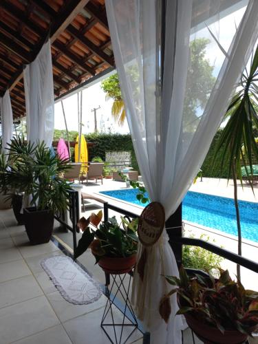 a patio with a table and plants and a pool at Casa das Seringueiras in Alter do Chao