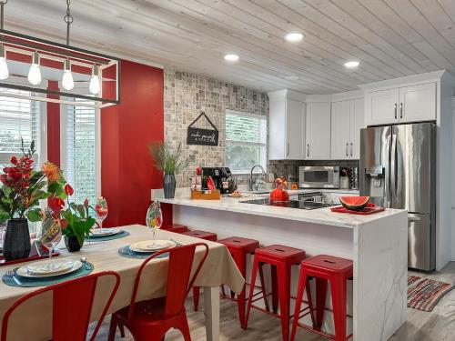 eine Küche mit roten Wänden und einer Theke mit roten Stühlen in der Unterkunft SolMate Free Golf Cart & Pool Heat Deals in Destin