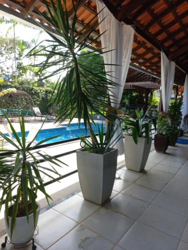 a row of potted plants sitting next to a pool at Casa das Seringueiras in Alter do Chao