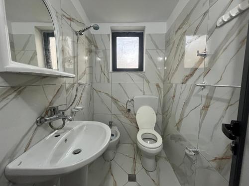 a bathroom with a toilet and a sink at Rei’s place in Vlorë