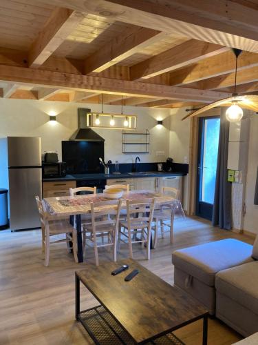 une cuisine et un salon avec une table et des chaises dans l'établissement Grange Nere Le Clos des Ours, à Matemale