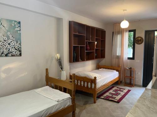 a bedroom with two beds and a shelf at Rei’s place in Vlorë