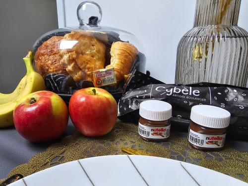 a table with apples and peanut butter and some food at Maison équipée avec petit déjeuner gratuit - balnéo- sauna - siège massant et pièce secrète in Brachy