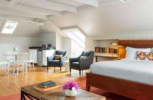 a bedroom with a bed and a kitchen and a table at Oakhurst Inn at the University in Charlottesville