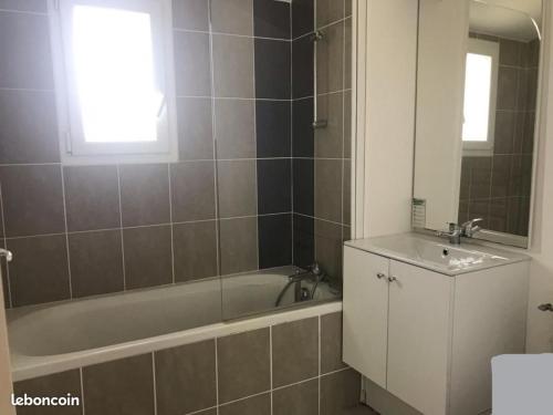 un baño con bañera y lavabo en Maison 4-6 personnes, en Saint-Brevin-les-Pins