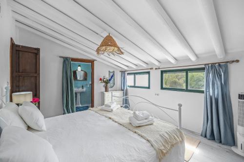a bedroom with a large white bed and a window at Casa Magnolia in Galaroza