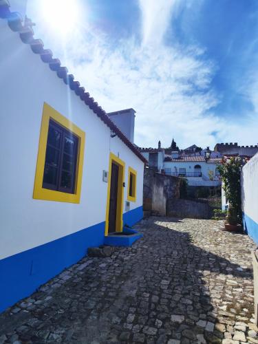 a blue and white house with a yellow door at Casa Nº11 - Vila d'Óbidos in Óbidos
