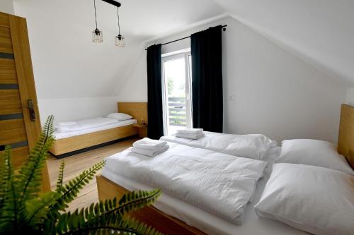 een slaapkamer met twee bedden en een groot raam bij Domki na Krótkiej in Spytkowice