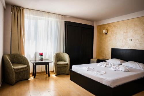 Habitación de hotel con cama, 2 sillas y mesa en Complex Vraja Mării Costinești, en Costinesti