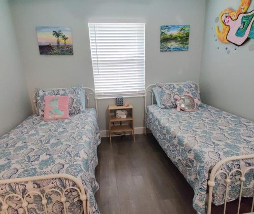 a bedroom with two beds and a night stand at Paradise Beach Oasis in Indialantic