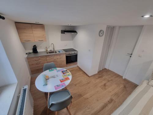a small kitchen with a small table and a table and chair at L'impossible in Spa