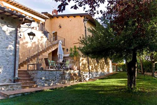 a building with stairs and a table and an umbrella at Casale del Monsignore in Spoleto