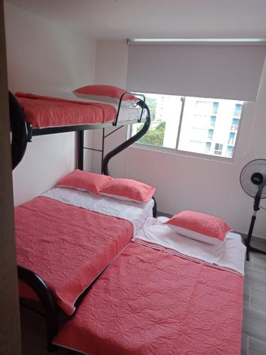 two bunk beds in a room with a window at Espectacular Apartamento Ricaurte Girardot in Ricaurte